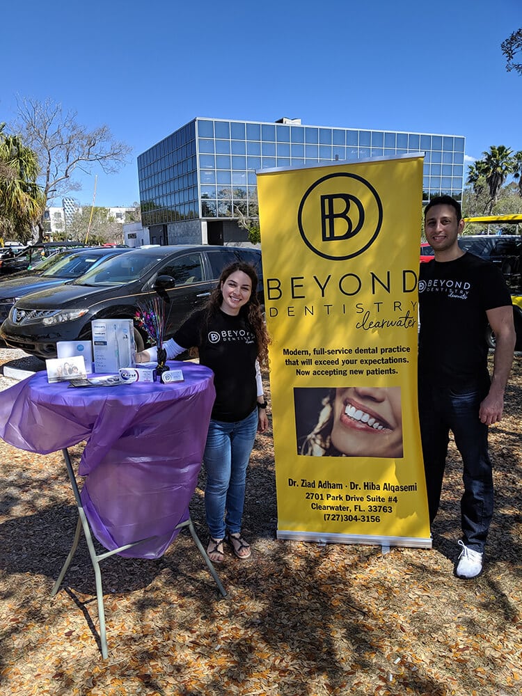 Dr. Ziad Adham & Meet Dr. Hiba Alqasemi Outside in Front of Beyond Dental Banner