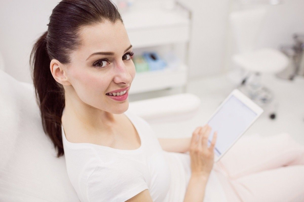 Woman reviewing cosmetic dentistry veneer treatment options during a consultation in dental office.